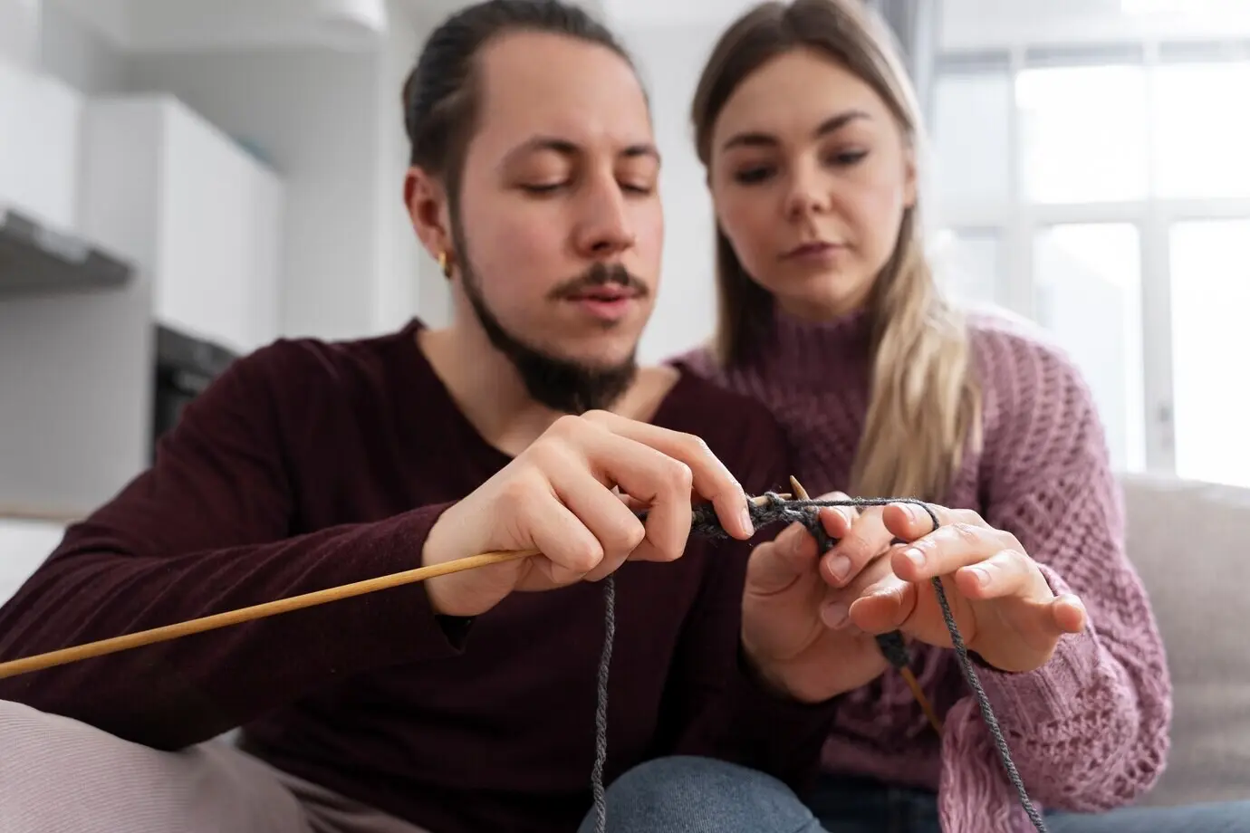 Ein junges Paar strickt gemeinsam.